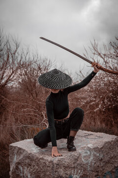 Samurai girl with a sword in the forest