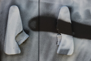 close up of an outdoor electrical cabinet or box - focus on the front door handles with padlocks - spray painted in black and white