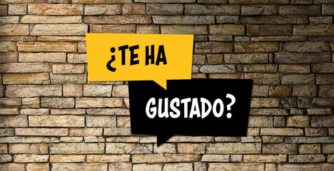 Fototapeta na wymiar speech bubbles with Spanish message for DO YOU LIKE IT? on a brick wall background