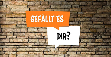 Fototapeta na wymiar speech bubbles with German message for DO YOU LIKE IT? on a brick wall background
