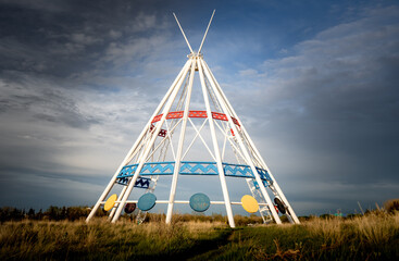 Medicine Hat Alberta Canada, May13 2021: The world's tallest tepee standing under a dramatic sky next to the Trans Canada Hiway in a Canadian city. - obrazy, fototapety, plakaty