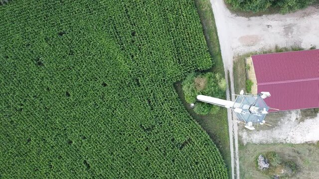 Ansbach, Germany Bavaria - August 22, 2020: Wide Area Network (WAN) 3G 4G 5G LTE mobile radio broadband transceiver communications tower with, corn field, building , and flyover from above.