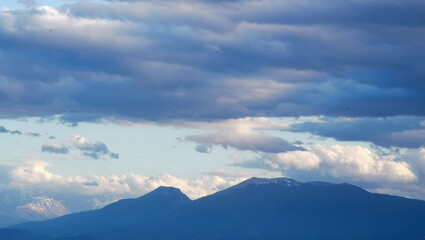 Grandi nuvole sopra le montagne dell’Appennino all’imbrunire in un cielo azzurro primaverile