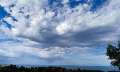 Fototapeta na wymiar Nuvole nel cielo sopra al mare viste dall’alto delle colline