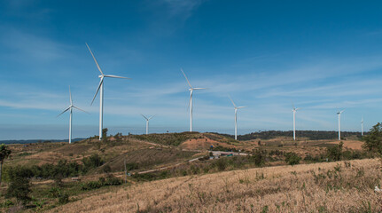 Wind turbines generating electricity over blue sky