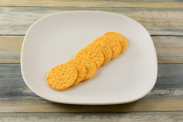 Cheese crackers in a row on white snack plate on table