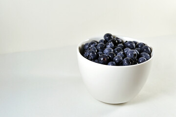 Fresh blueberries bowl on white background.