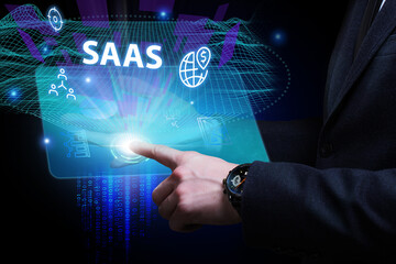 Business, Technology, Internet and network concept. Young businessman working on a virtual screen of the future and sees the inscription: SAAS