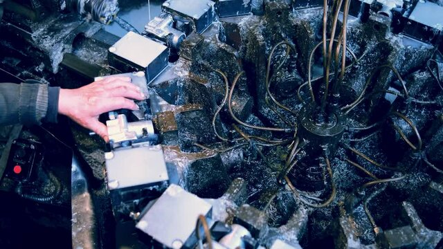 Factory for the production of spare parts for cars and tractors. Aggregate machine tool. A worker inserts an aluminum billet for processing. Top view.