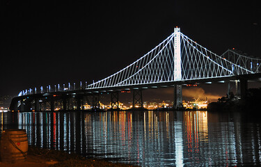 Bridge over bay at night with light reflections on water