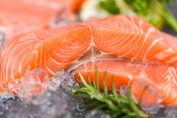 Fresh salmon fish on ice, Raw salmon filet with lemon rosemary herbs and spices
