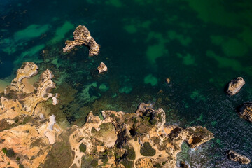 Camilo Beach in Lagos, Algarve - Portugal. Portuguese southern golden coast cliffs. Sunny day aerial view.