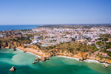 Dona Ana Beach in Lagos, Algarve - Portugal. Portuguese southern golden coast cliffs. Aerial view with city in the background. Camilo and pinhao beach.