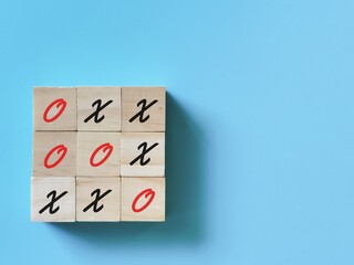 Wooden cubes with tic tac toe board game isolated on blue background.