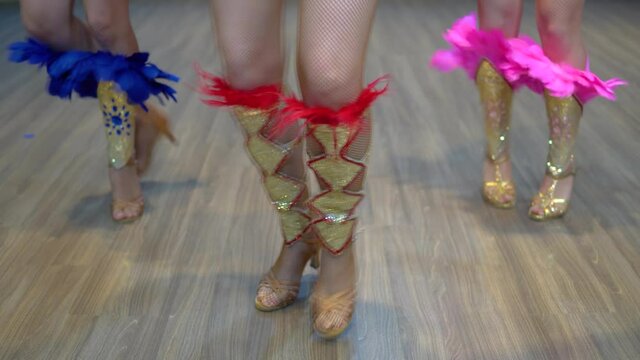 Dancing samba legs close-up, three girls practice dancing samba at the studio wearing show costumes