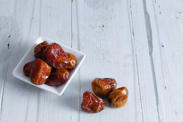 Dates fruits on white wooden table, with copy space. Organic dried dates fruits.