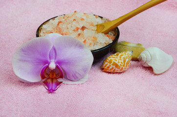 Concept of beauty, health, spa, body care at home, orchid flower, wooden spoon, seashells and sea salt pink himalayan, copy space text