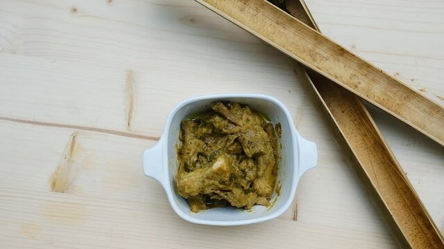A footage of "lemang" serve with chicken "rendang". Lemang is rice cook in bamboo. Rendang is meat cooked slowly in coconut milk and various spices until fairly dry.