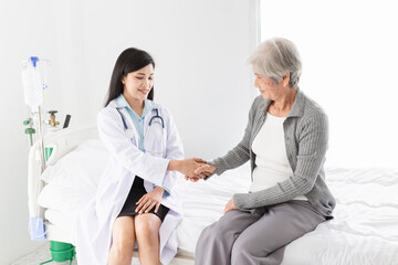 close up old patient,  Asian doctor talk with old female patient about disease symptom, they holding hand together, elderly health check up, happiness hospital, hand in hand