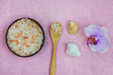 Concept of beauty, health, spa, body care at home, orchid flower, wooden spoon, seashells and sea salt pink himalayan, copy space text