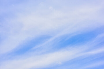 Fototapeta premium Hazy small cirrostratus, cirrocumulus and cumulus cloud formations on a sunny afternoon in late summer are contrasted against the blue sky.