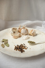 Cooking seasoning set: garlic, bay leaf, pepper and herbs on a handmade ceramic plate. . High quality photo