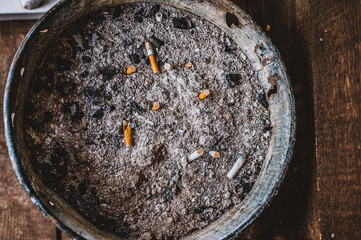 cigarette ash bucket sitting on a wooden porch in a rural setting © Lost_in_the_Midwest