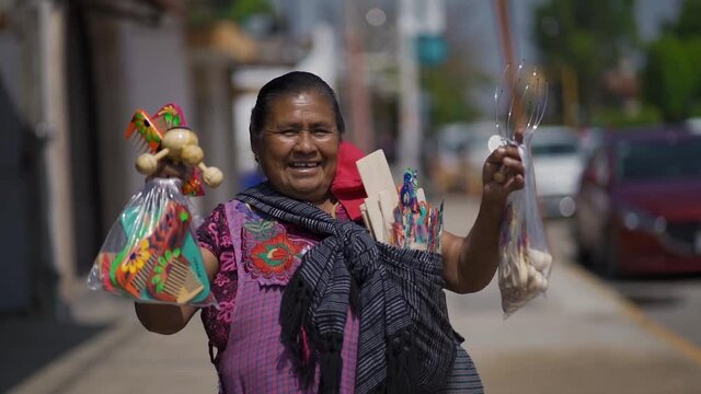 indigenous Mexican woman looking at camera.street vendor woman showing handicrafts to camera and smiling. Oaxaca, Mexico