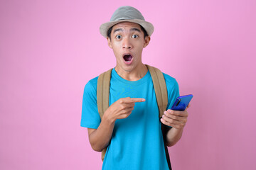 Shocked male tourist with smartphone booking tour online, surprised over big vacation discount