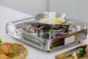 Steam eggs in small pan on mini gas stove  for breakfast.