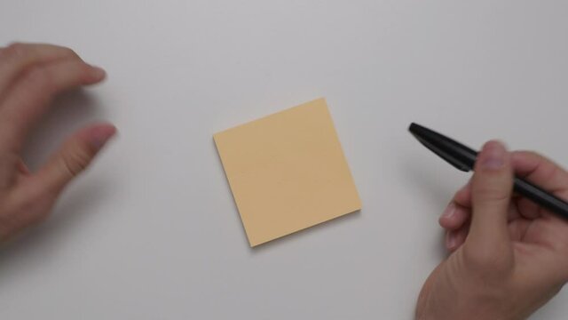 Set of hands ready to write down an idea on a note pad.