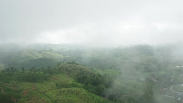 Flying through misty clouds above green tropical hills of Hatton, Sri Lanka