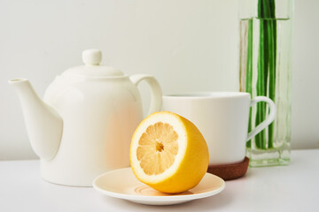 Teapot, cup and flowers on white background