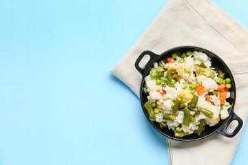 Frying pan with cooked vegetables and rice on color background - obrazy, fototapety, plakaty
