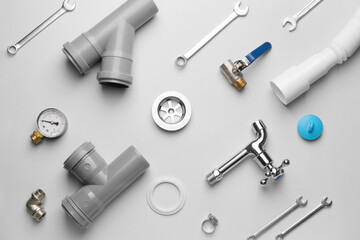 Set of plumber's items on light background