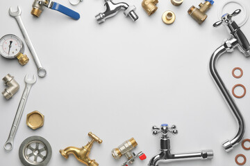 Frame made of plumber's items on light background
