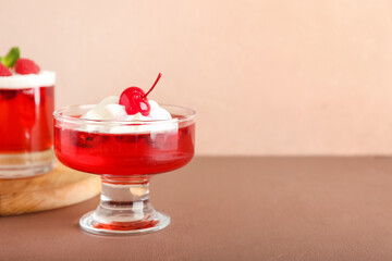 Glasses of tasty raspberry jelly on color background