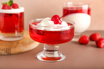 Glasses of tasty raspberry jelly on color background