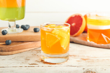 Glass of tasty jelly on light wooden background