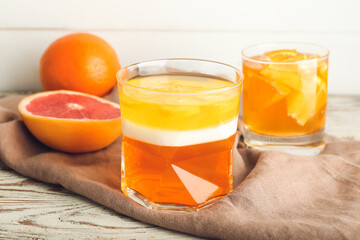 Glass of tasty jelly on light wooden background