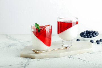 Glasses of tasty jelly on light background