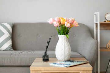 Tulip flowers and magazine on wooden table in room