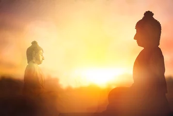 Gordijnen Vesak Day concept: Silhouette Buddha on golden sunset background © paul