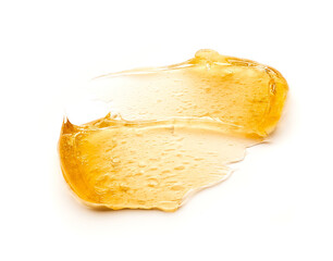 Transparent yellow smear of face cream or golden honey isolated on white background. Golden creamy...