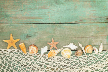 Summer wooden background with seashells, starfishes, netting and place for text