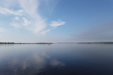 A motor boat sails from the island forward on a cloudy spring day