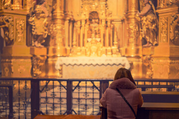 Fototapeta na wymiar A woman in a temple prays to God. Woman praying in front of altar. Praying woman in front of altar. selected focus