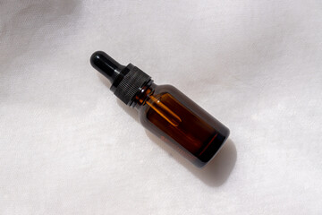 Amber glass Serum bottle on marble background. Trendy beauty product for young skin. Additional...