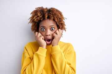 Mixed race woman wearing casual clothes is shocked with surprised face, touching face. unbelieving expression. Female with wide opened eyes look at camera at a loss, isolated white background