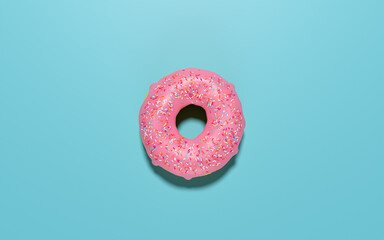 Flay lay view of a one donut with pink icing and sprinkles.